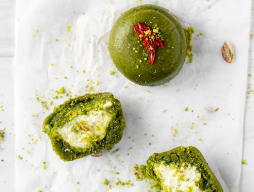 Brush pistachio pesto on bottom of a serving plate and top with arugula